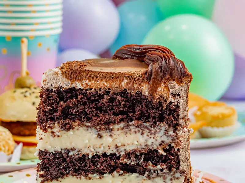 Fatia de torta de chocolate com recheio cremoso branco entre as camadas