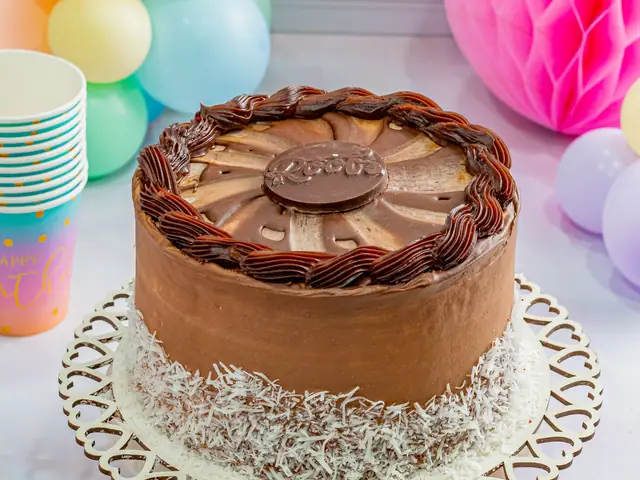 Torta de chocolate decorada com bicos de ganache e coco ralado na base