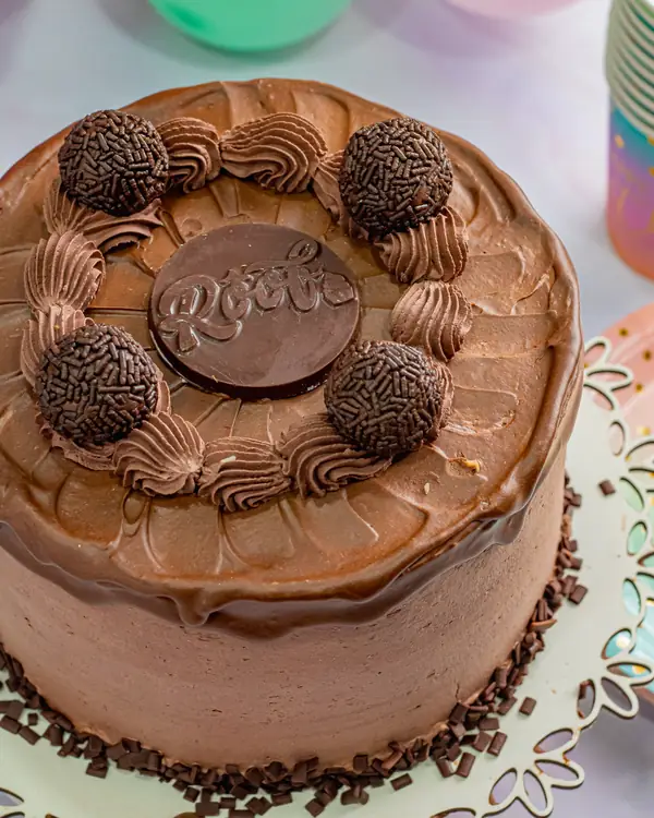Torta chocolatudo com cobertura de chocolate, brigadeiros e granulado na base